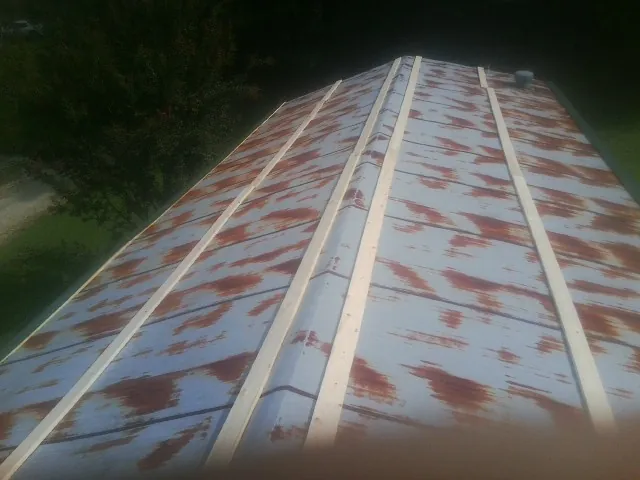 Rusted metal roof panels with new wood purlins before replacement — Storm Damage Roof Repair in Summit Point by Roofing Brothers