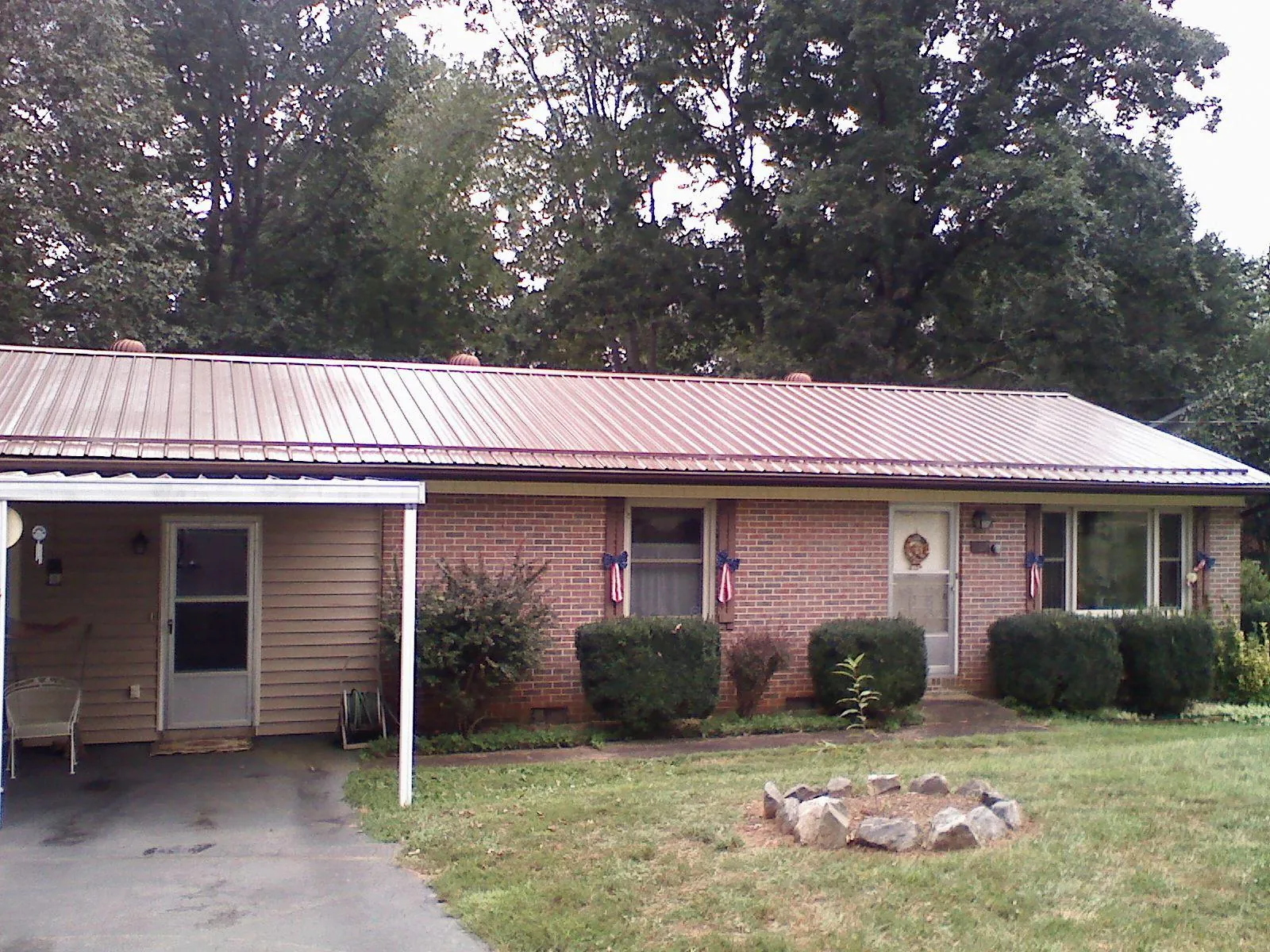 Bronze metal roof and carport on a brick ranch home — Roof Repair work by our crew in Summit Point